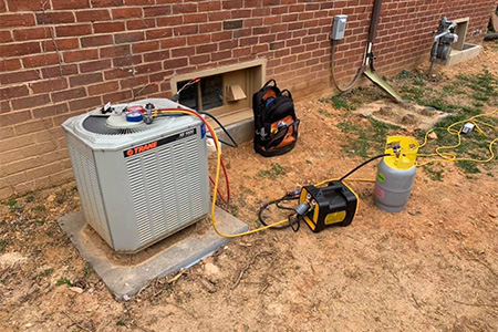 An outdoor air conditioning unit undergoing repair service.