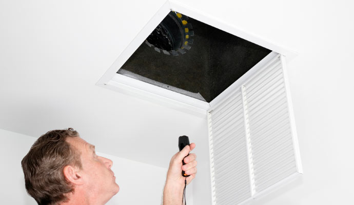 a person inspecting a duct