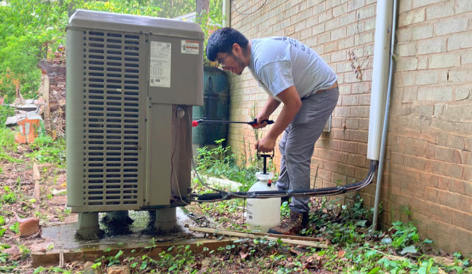 a person performing maintenance on a hvac system