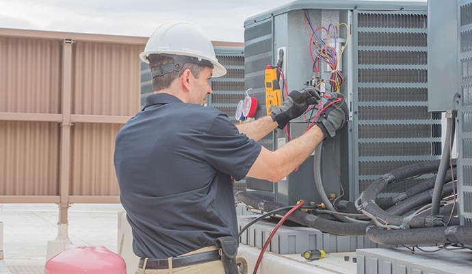 A person repairing an air conditioning unit